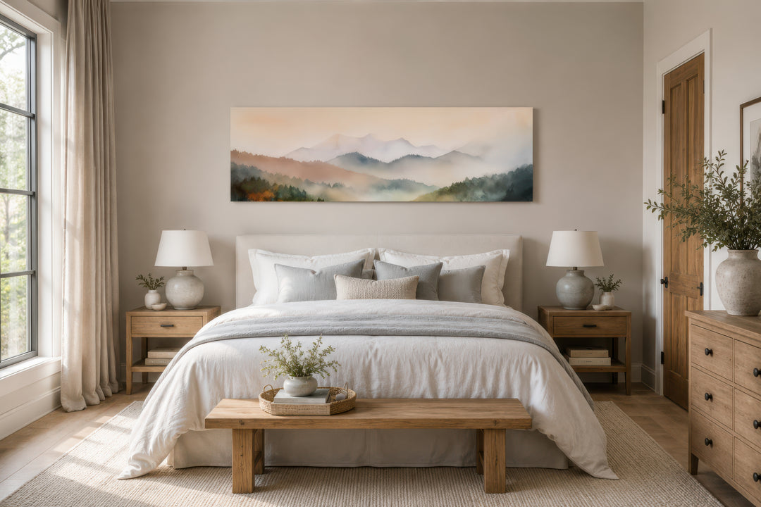 A wide canvas print of a misty pink and green mountain landscape hangs above a neutral-toned bed.