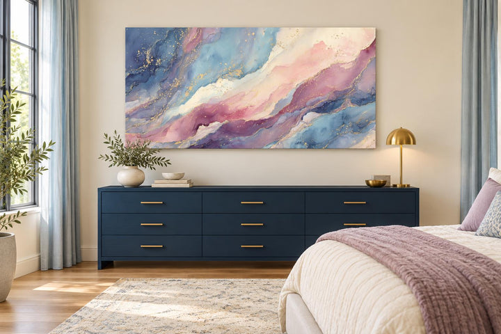 Pink and blue abstract marble framed canvas wall art hanging above a navy blue dresser in a bedroom.