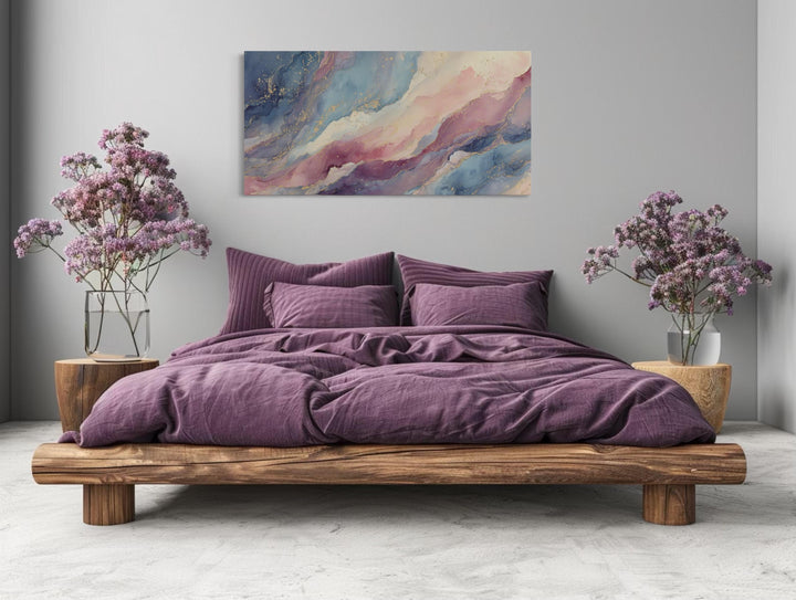 Pink and blue abstract marble canvas wall art hanging above a bed with purple bedding.