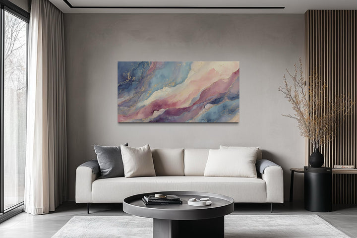 Pink and blue abstract marble framed canvas wall art hanging above a modern sofa in a living room.