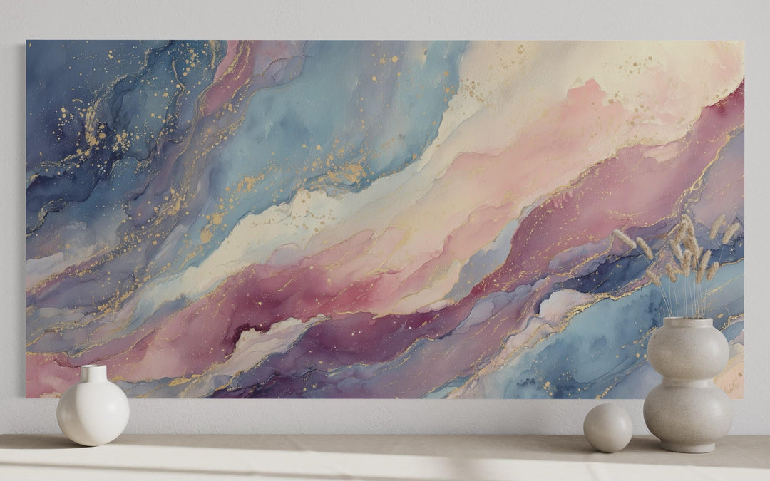 Pink and blue pastel abstract marble canvas wall art with gold accents above a neutral shelf.