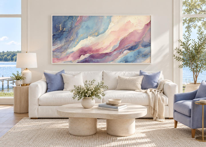 Pink and blue abstract marble framed canvas wall art hanging above a white sofa in a living room.