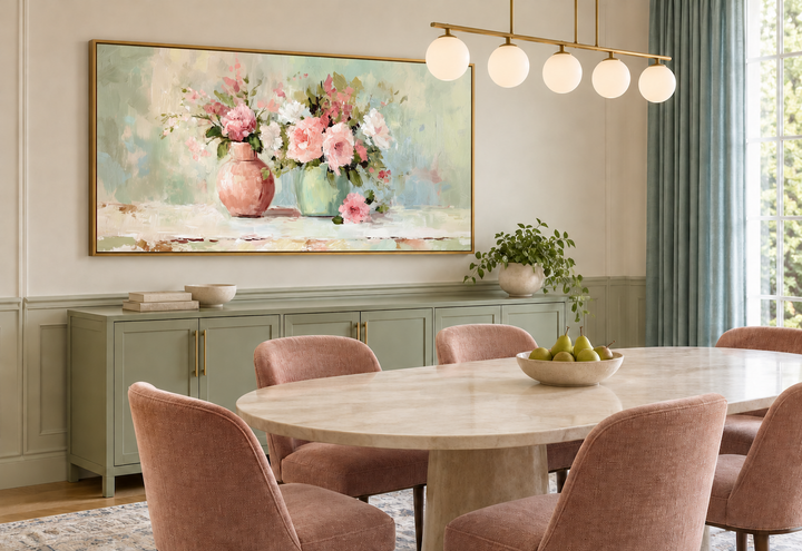 Pink and green floral painting in a gold frame above a green sideboard in a dining room.
