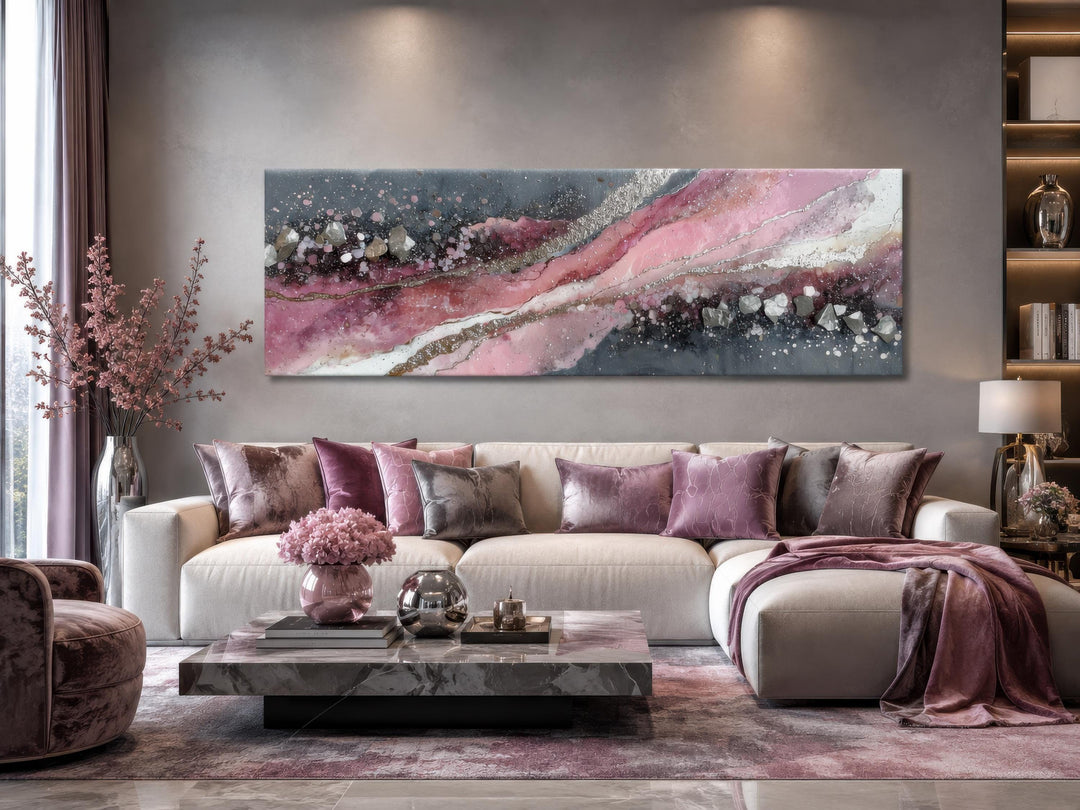 Long horizontal canvas print with a pink and grey geode-inspired abstract design above a sofa.