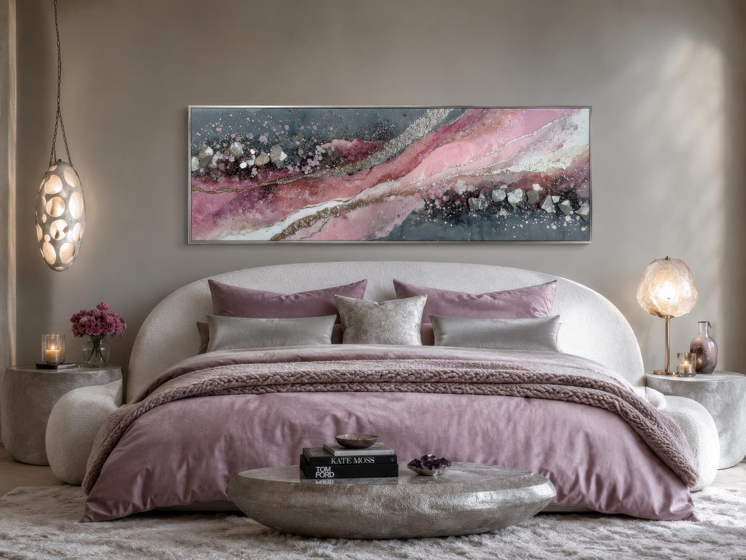 Long horizontal pink and grey abstract geode canvas print hanging above a modern bed.