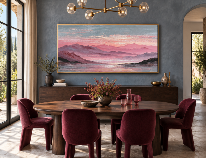 Pink mountain landscape canvas print in a gold frame above a dark wood sideboard in a dining room.