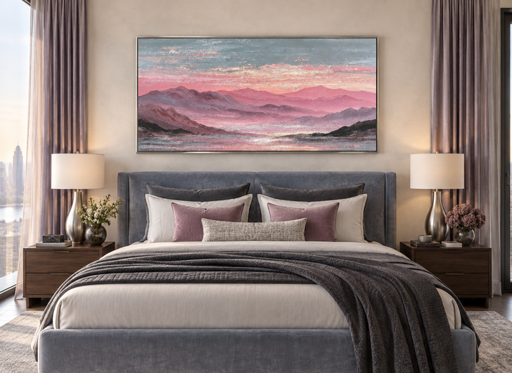 Mountain landscape canvas print with pink and grey sunset tones above a modern upholstered bed.