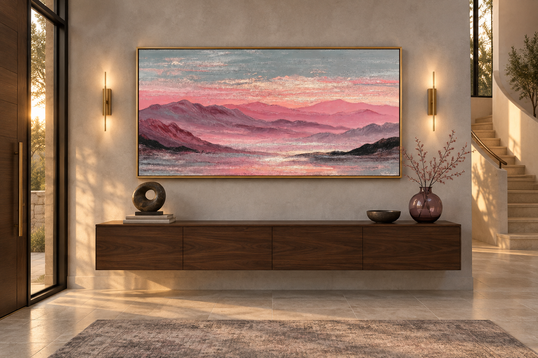 Pink mountain landscape canvas print with soft blush sunset over a dark wood floating console.