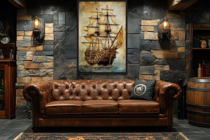 Pirate ship on antique treasure map nautical framed canvas wall art above a brown leather sofa.