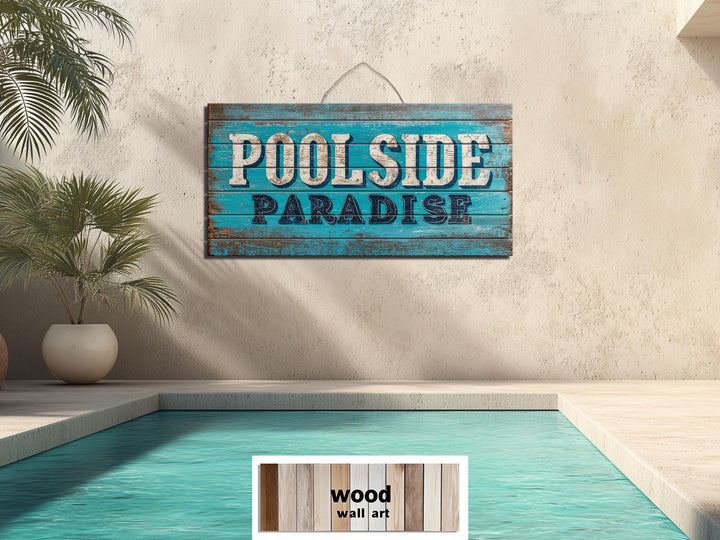 A rustic wood wall art sign reading Poolside Paradise hangs above a swimming pool.
