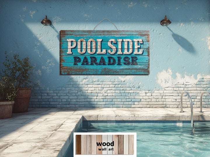 A rustic wood wall art sign reading Poolside Paradise hangs on a blue wall above a swimming pool.