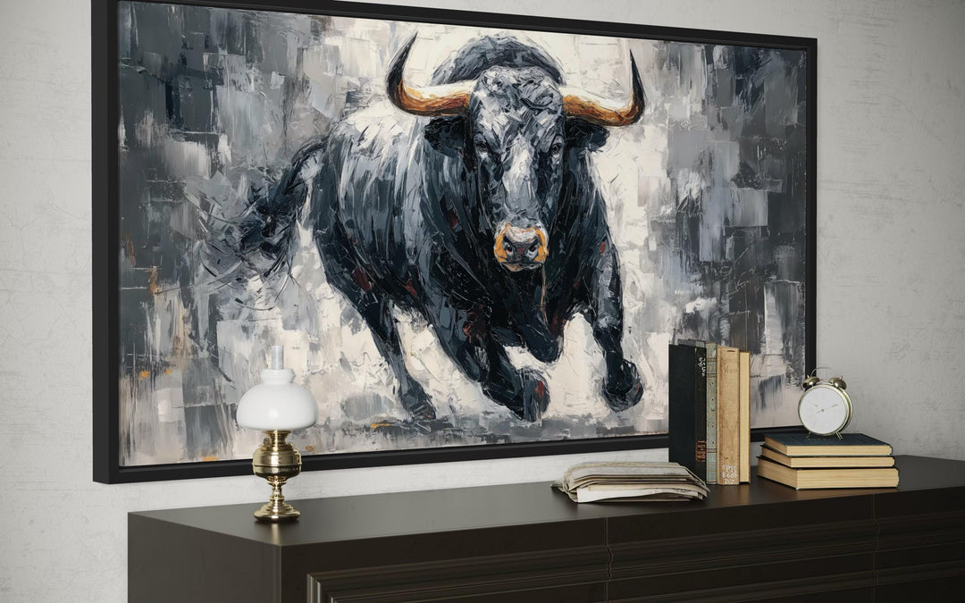 Charging Black Bull canvas wall art in a black frame above a dark wood dresser in a modern office.