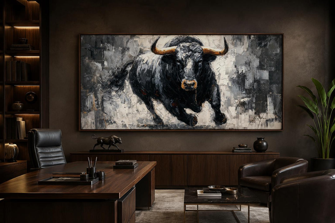 Large horizontal canvas wall art of a charging black bull in a modern dark wood office setting.