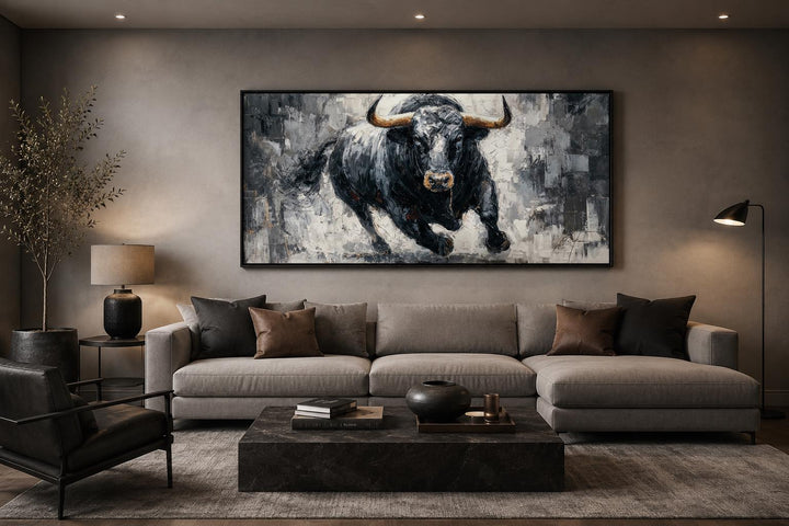 Charging black bull canvas wall art in a modern living room above a grey sectional sofa.