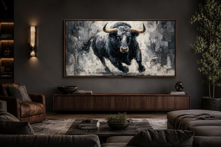 Large framed canvas wall art of a charging black bull in a modern, dark-toned office setting.