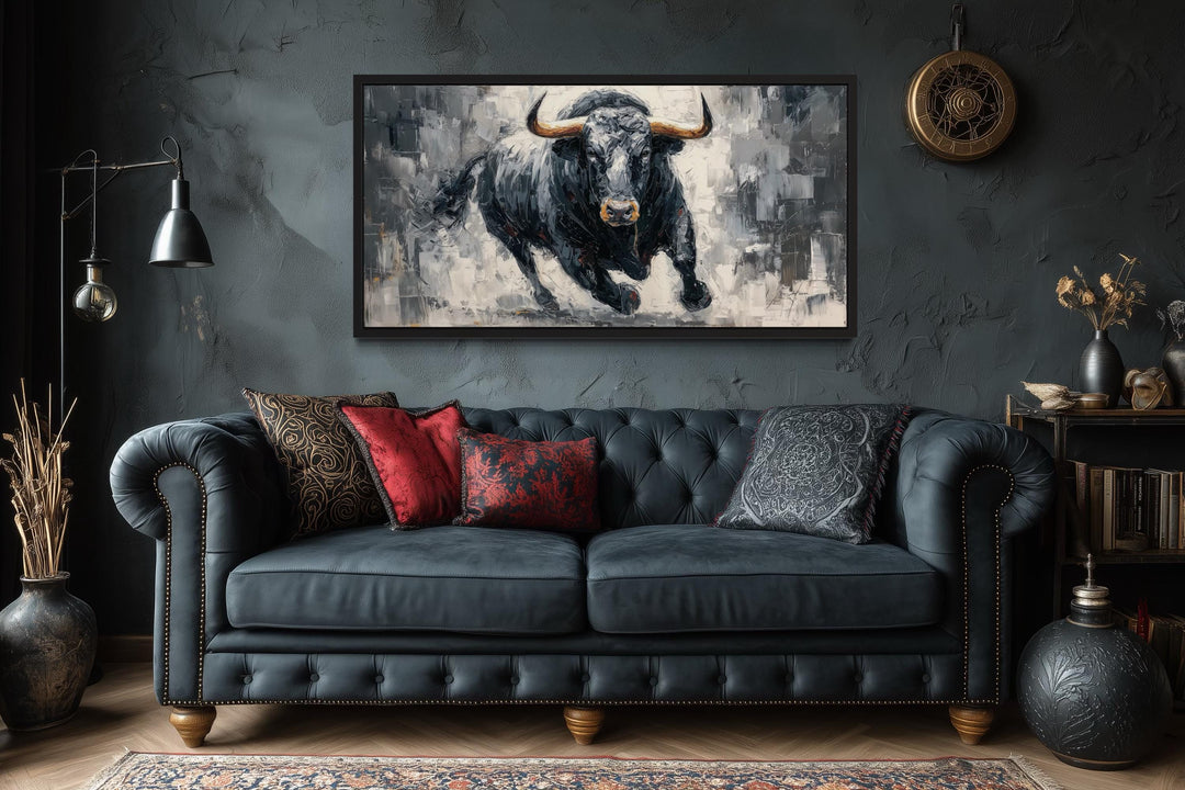 Charging Black Bull canvas wall art in a dark, modern office setting above a tufted leather sofa.