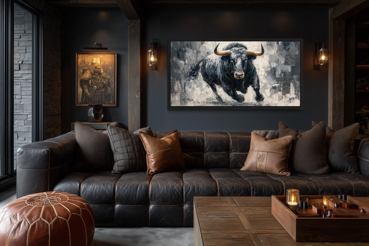 Charging black bull canvas wall art in a dark, modern office with a leather sofa and wood table.