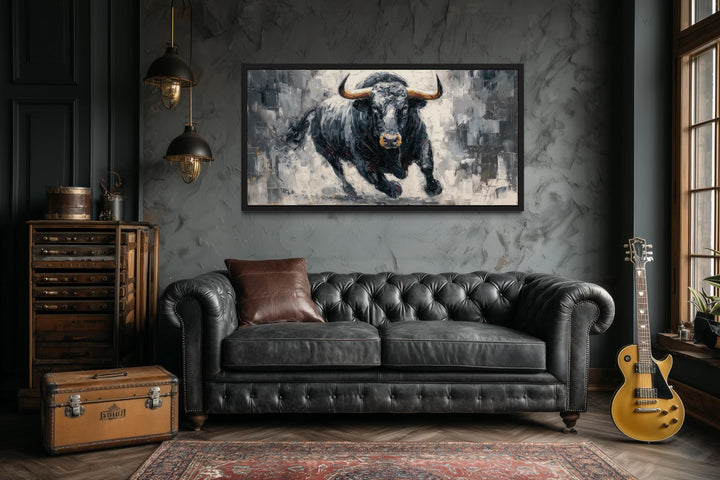 Charging Black Bull canvas wall art in a black frame above a dark leather sofa in a modern office.