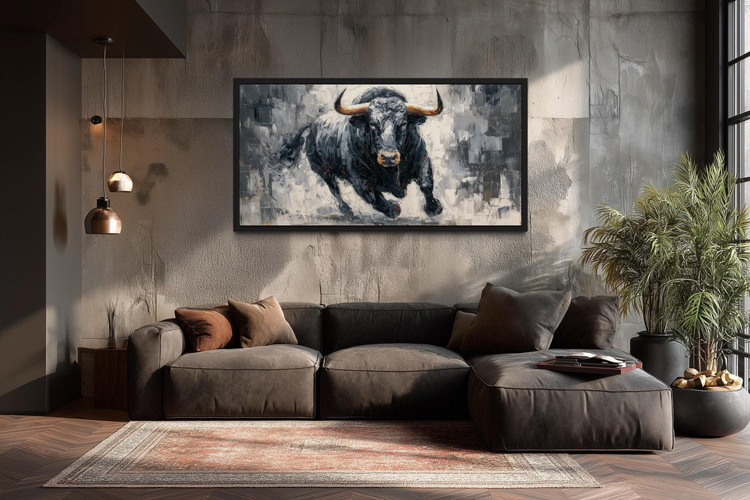 Charging black bull canvas wall art in a modern living room with a dark sofa and concrete wall.