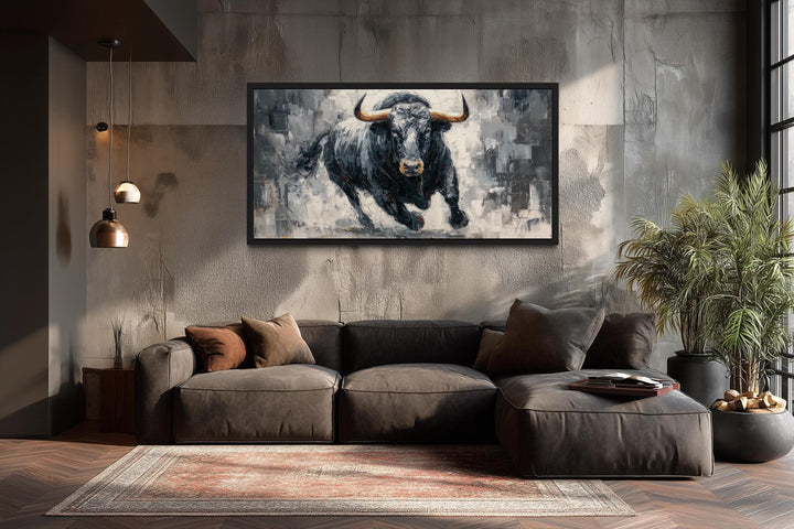 Charging black bull canvas wall art in a modern living room with a dark sofa and concrete wall.