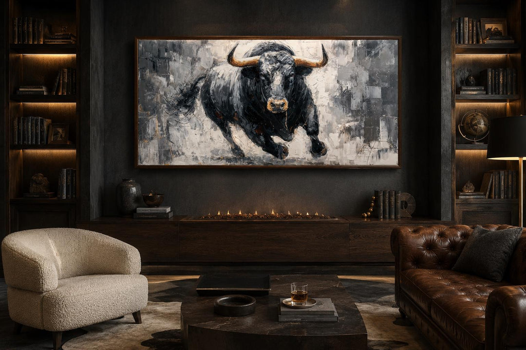 Charging black bull canvas wall art in a dark, modern office with leather furniture and a fireplace.