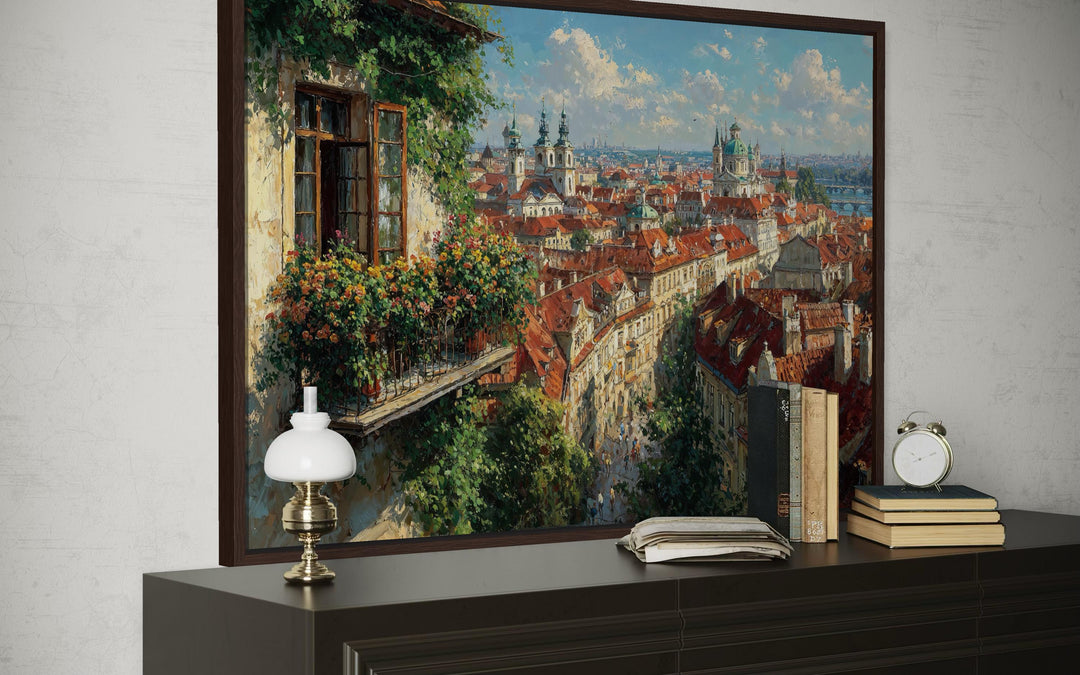 Prague cityscape canvas art with red roofs and a flower-filled balcony view on a dark wood console.