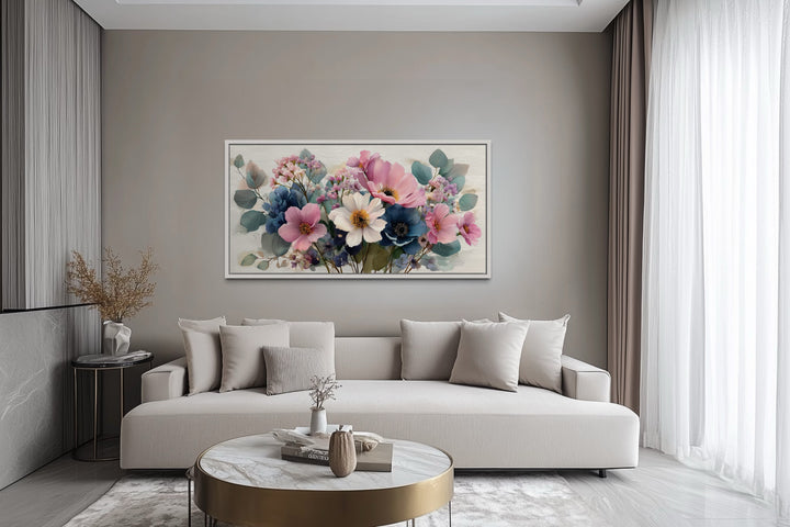 Pretty blue and pink wildflowers bouquet framed canvas wall art hanging above a modern sofa.