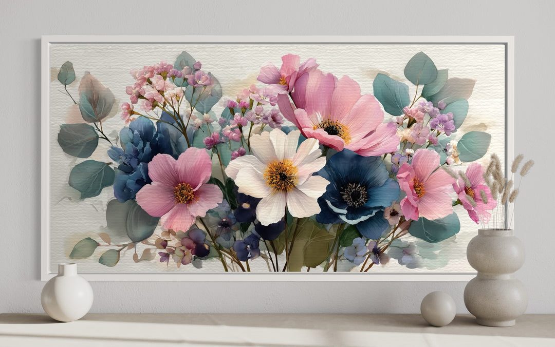 Pretty blue and pink wildflower bouquet framed canvas wall art displayed above a neutral shelf.