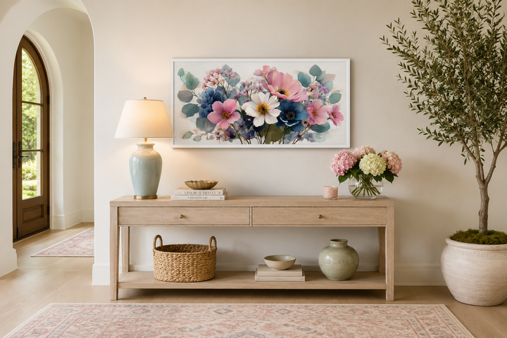 Framed canvas wall art of a blue and pink wildflower bouquet above a wooden console table.