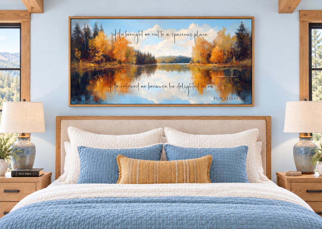 Psalm 18:19 canvas art featuring an autumn lake painting above a bed in a bright bedroom.