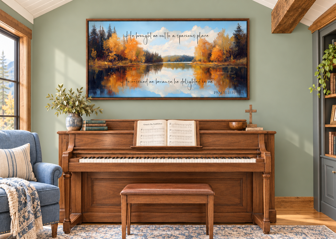 Psalm 18:19 canvas art featuring an autumn lake painting above a wooden piano in a cozy room.