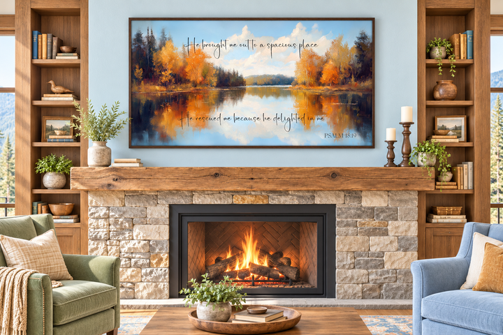 Psalm 18:19 canvas art featuring an autumn lake painting above a stone fireplace in a cozy room.