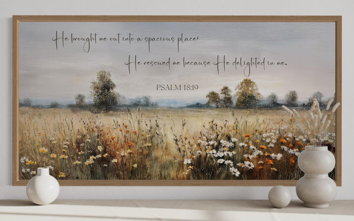Psalm 18:19 scripture wall art featuring a wildflower field landscape in a wooden frame.