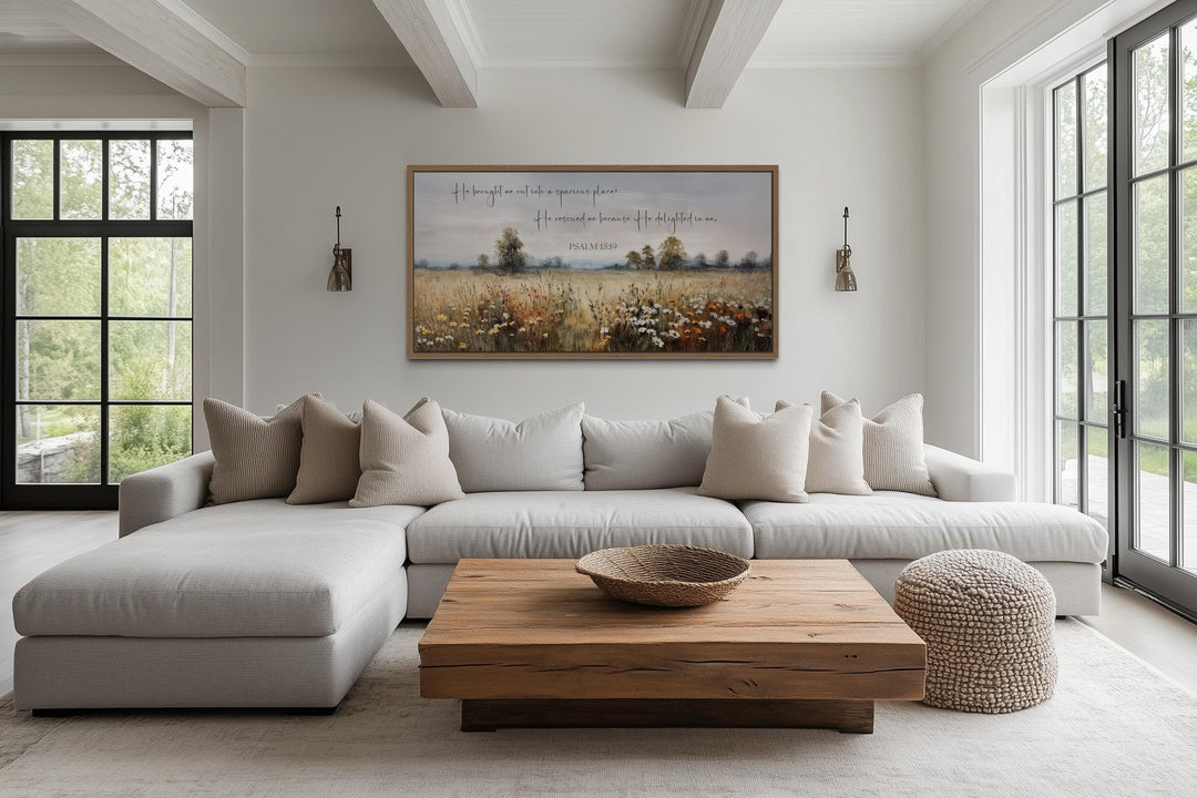 Psalm 18:19 scripture wall art featuring a wildflower field landscape in a modern living room.