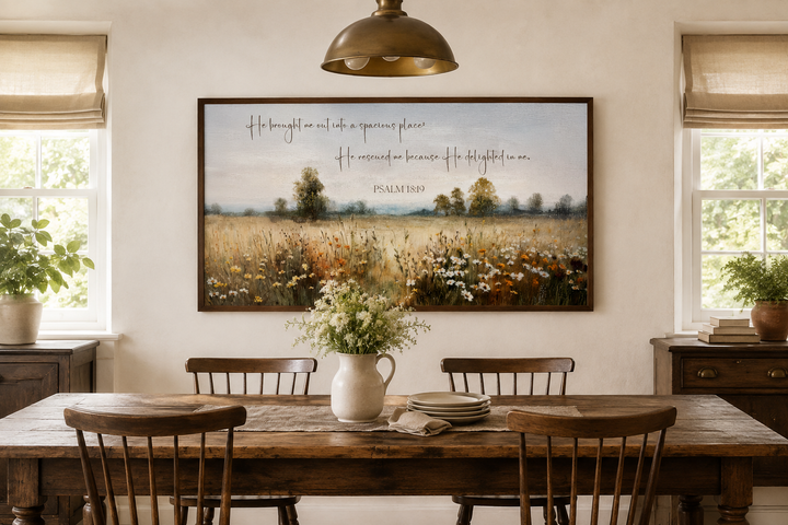 Psalm 18:19 scripture on a framed canvas painting of a wildflower field in a rustic dining room.
