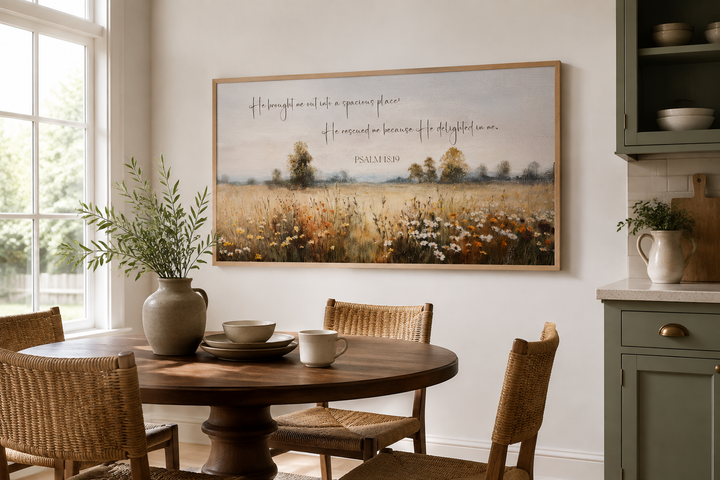 Psalm 18:19 scripture on a framed canvas painting of a wildflower field in a dining room.