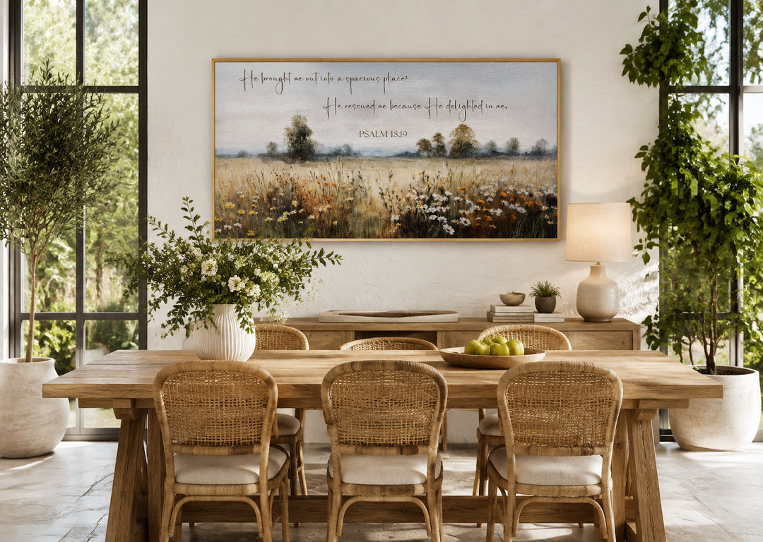Psalm 18:19 scripture on a framed canvas painting of a wildflower field in a rustic dining room.