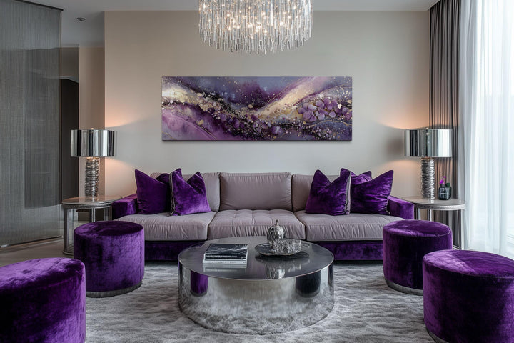 Horizontal purple abstract canvas art with gold accents hung above a modern velvet sofa.