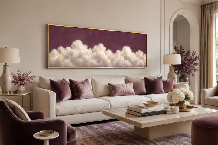 Long narrow canvas print of white fluffy clouds on a deep purple background in a gold frame.