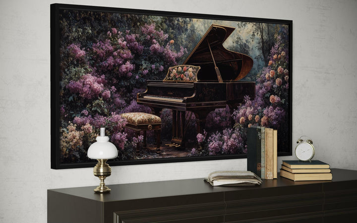 A framed canvas print of a grand piano surrounded by lush purple flowers on a dark console table.