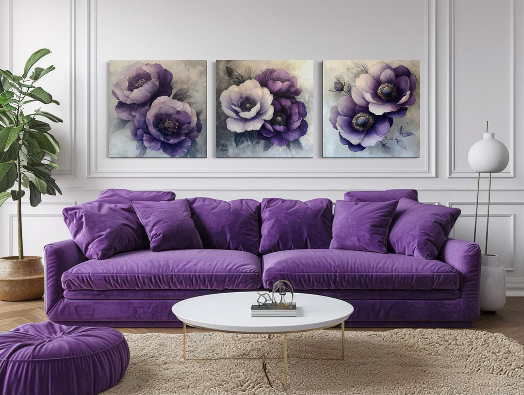 Set of three purple floral canvas prints hanging above a purple sofa in a modern living room.