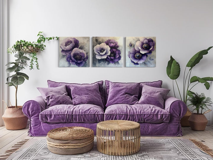 Set of three purple floral canvas prints hanging above a violet velvet sofa in a modern living room.