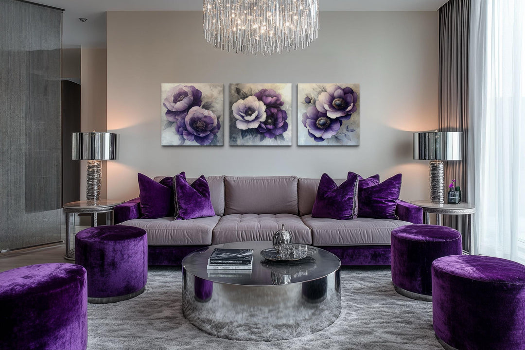 Set of three purple floral canvas prints displayed above a grey sofa with purple velvet pillows.