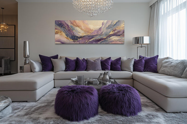 A long horizontal framed canvas featuring an abstract purple and gold marble design above a sofa.