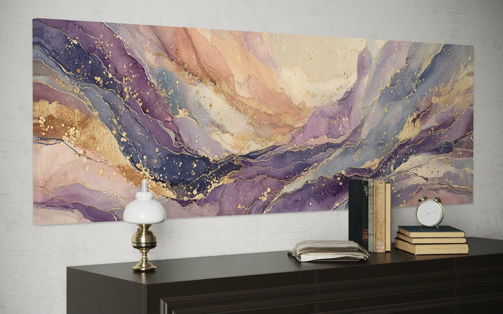 Long horizontal abstract canvas wall art featuring purple and gold marble patterns on a gray wall.