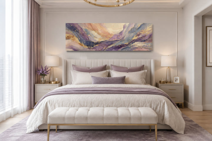 Long horizontal abstract framed canvas wall art with purple and gold marble patterns over a bed.