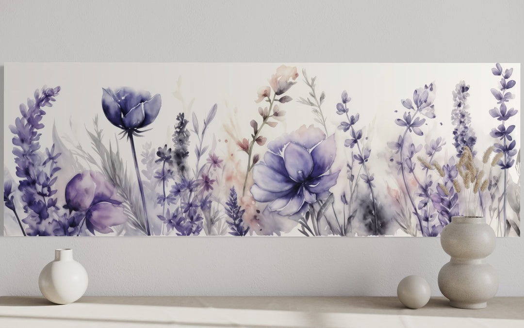 Panoramic watercolor canvas art of purple lavender and wildflowers above a neutral shelf with vases.