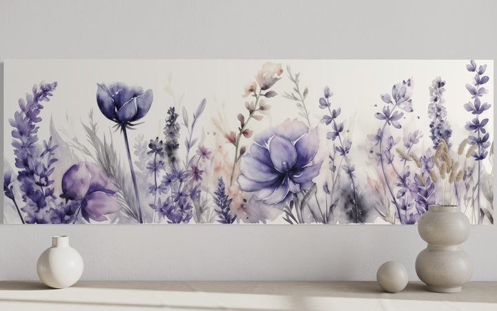Panoramic watercolor canvas art of purple lavender and wildflowers above a neutral shelf with vases.