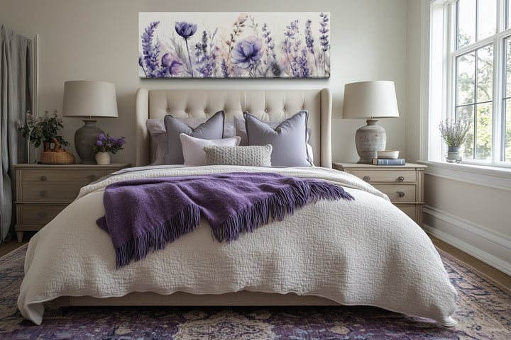 Panoramic framed canvas wall art of purple lavender wildflowers hanging above a bed.