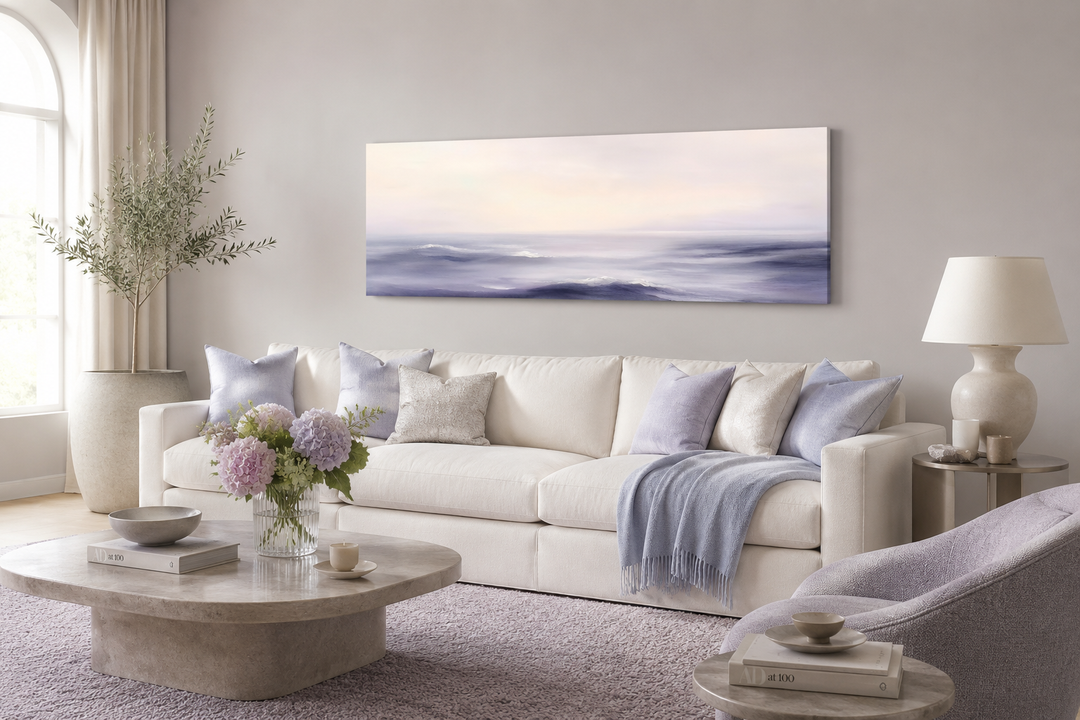 Purple Ocean Waves long horizontal coastal canvas wall art above a white sofa in a living room.